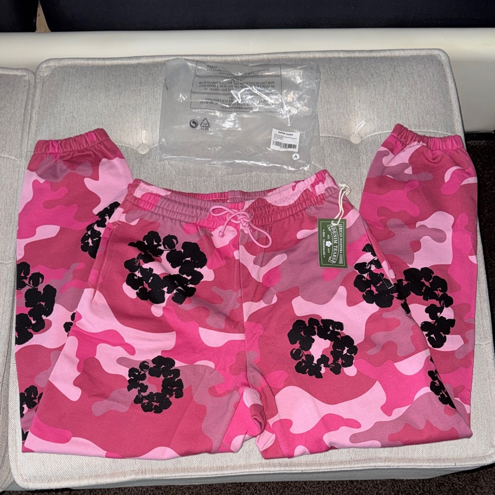 Denim Tears pink and black camouflage wreath bottoms with a camo design. Unisex.